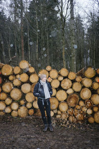 Full length of man standing on log in forest