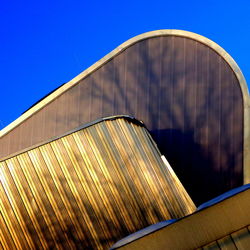 Low angle view of modern building against clear blue sky