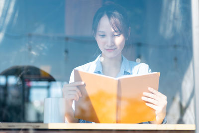 Portrait of young woman holding book