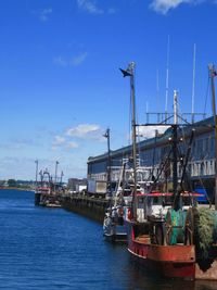 Ship moored at harbor against blue sky