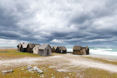Scenic view of beach against cloudy sky