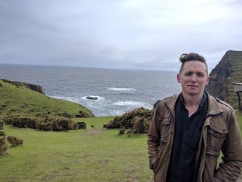 Portrait of young man standing against sea