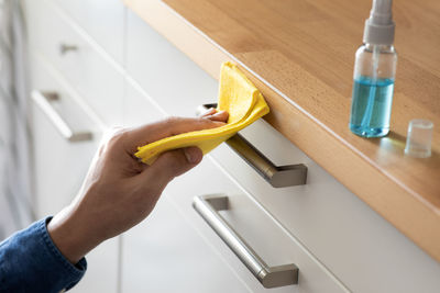 High angle view of woman holding stick on table at home