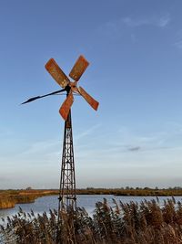 Windmill on field against sky