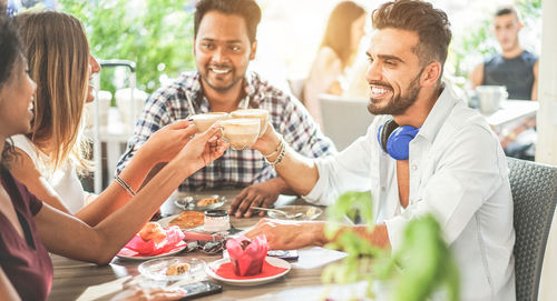 Happy friends having food at table