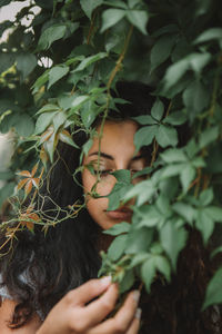 Close-up of young woman amidst plants