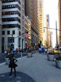 People walking on road amidst buildings in city