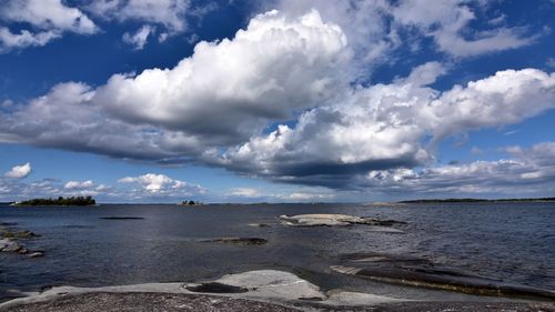 Scenic view of beach against cloudy sky