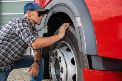 Side view of man repairing car