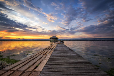 Pier over sea against sky during sunset