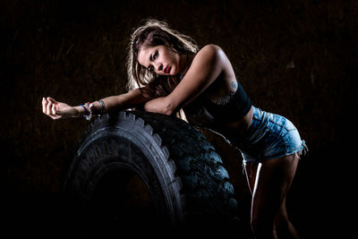 Portrait of woman standing by tire at gym