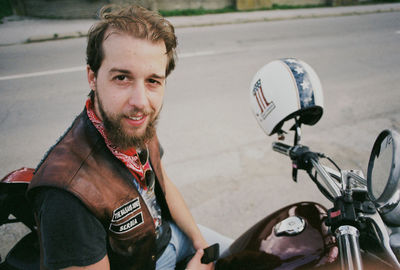 Portrait of smiling young man sitting on motorcycle