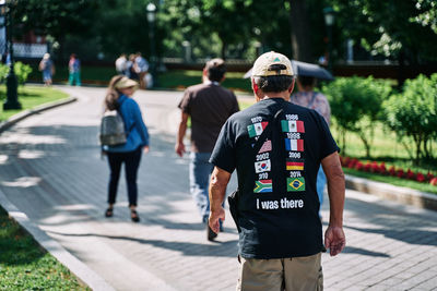 Rear view of people walking on street in city