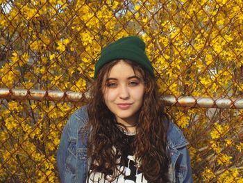 Portrait of beautiful young woman standing in autumn leaves