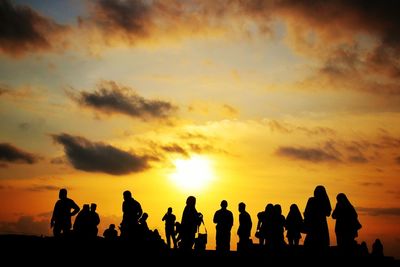 Silhouette people against sky during sunset