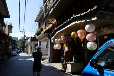 Rear view of woman on street against sky