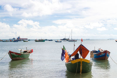 Boats moored on sea against sky