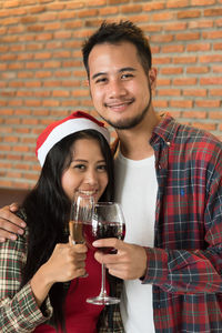 Close-up portrait of friends in santa hat having wine