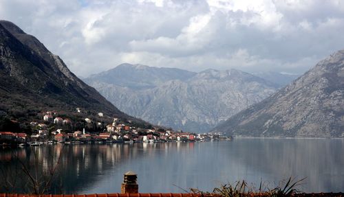 Scenic view of lake by mountains against sky