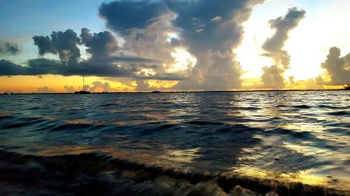 Scenic view of beach against sky at sunset