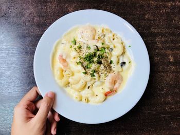 High angle view of hand holding macaroni cheese