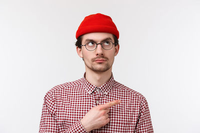 Portrait of young man wearing hat against white background