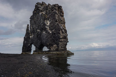 Rock formations on sea shore against sky