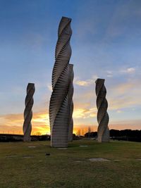 Built structure on field against sky at sunset