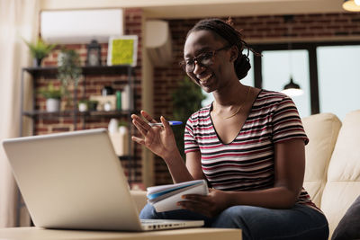 Young woman using laptop at cafe