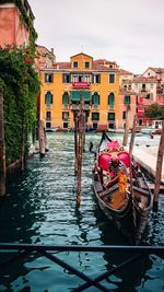 Canal amidst buildings in city against sky