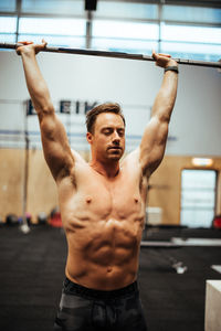 Shirtless man exercising in gym