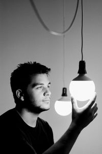Close-up of man holding light bulb