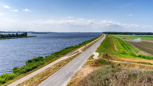 Scenic view of road by sea against sky