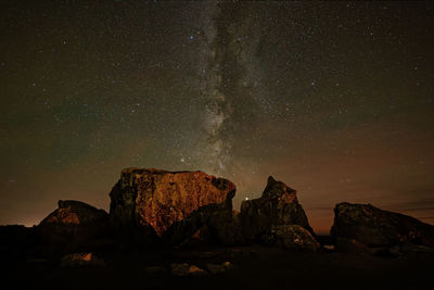 Rock formations against sky at night