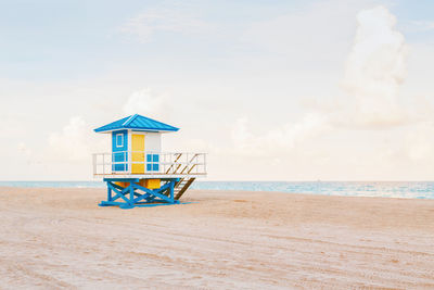 Lifeguard hut on beach against sky