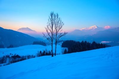 Scenic view of snowcapped mountains against sky during sunset