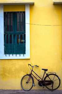 Bicycle against yellow wall of building