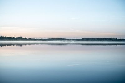 Scenic view of lake against sky during foggy weather