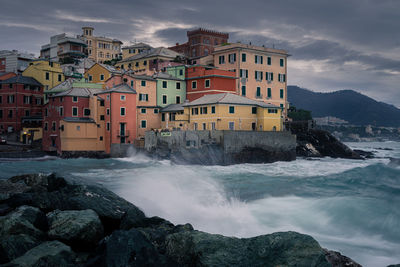 Scenic view of sea by buildings against sky