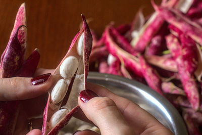 Woman hands peeling a bunch of beans