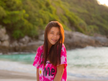 Portrait of beautiful woman standing on beach