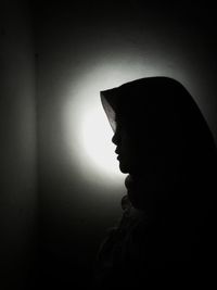 Close-up portrait of silhouette woman against wall