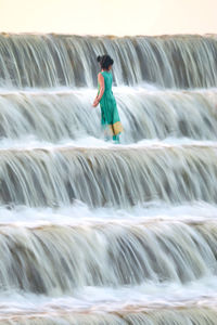 Woman standing with multi colored water