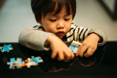 Boy arranging jigsaw puzzles on table