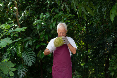 Man holding fruit on tree