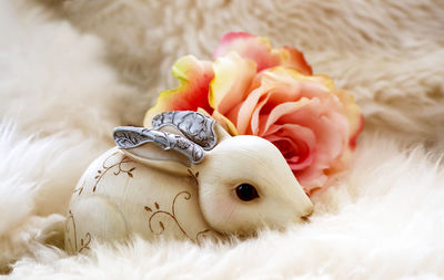 Close-up of artificial bunny and rose on fur during easter