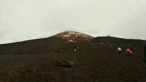 People on mountain against sky