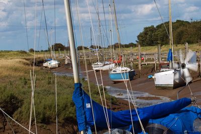 Sailboats moored on sea against sky