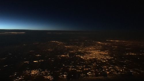 Aerial view of illuminated cityscape against sky at night