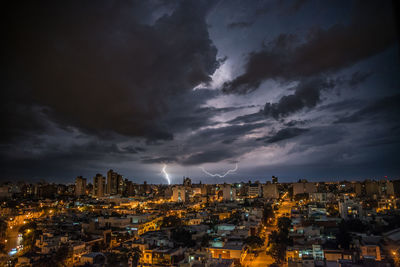 Aerial view of illuminated city against sky at night